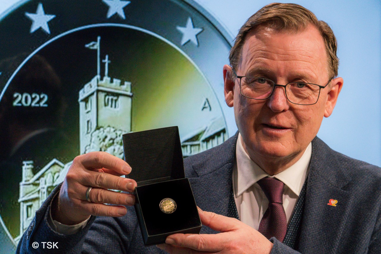 Bundesratspräsident Bodo Ramelow (Die Linke) hält die 2-Euro-Münze mit dem Thüringer Wahrzeichen hoch. 