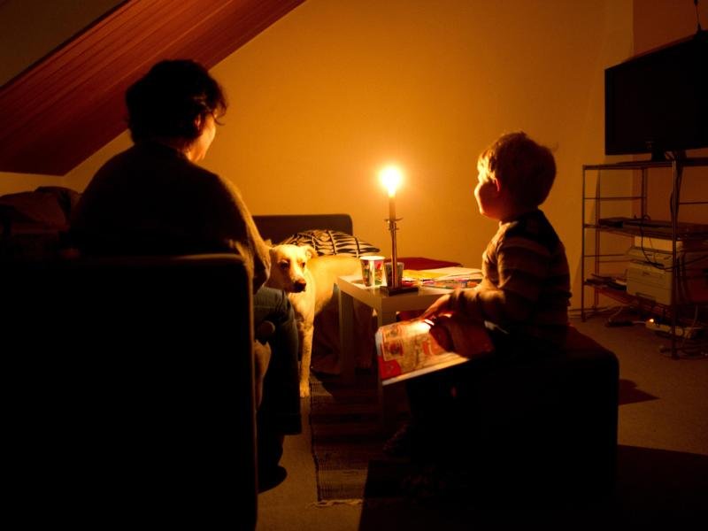 Eine Mutter sitzt mit ihrem Sohn in ihrer abgedunkelten Wohnung.