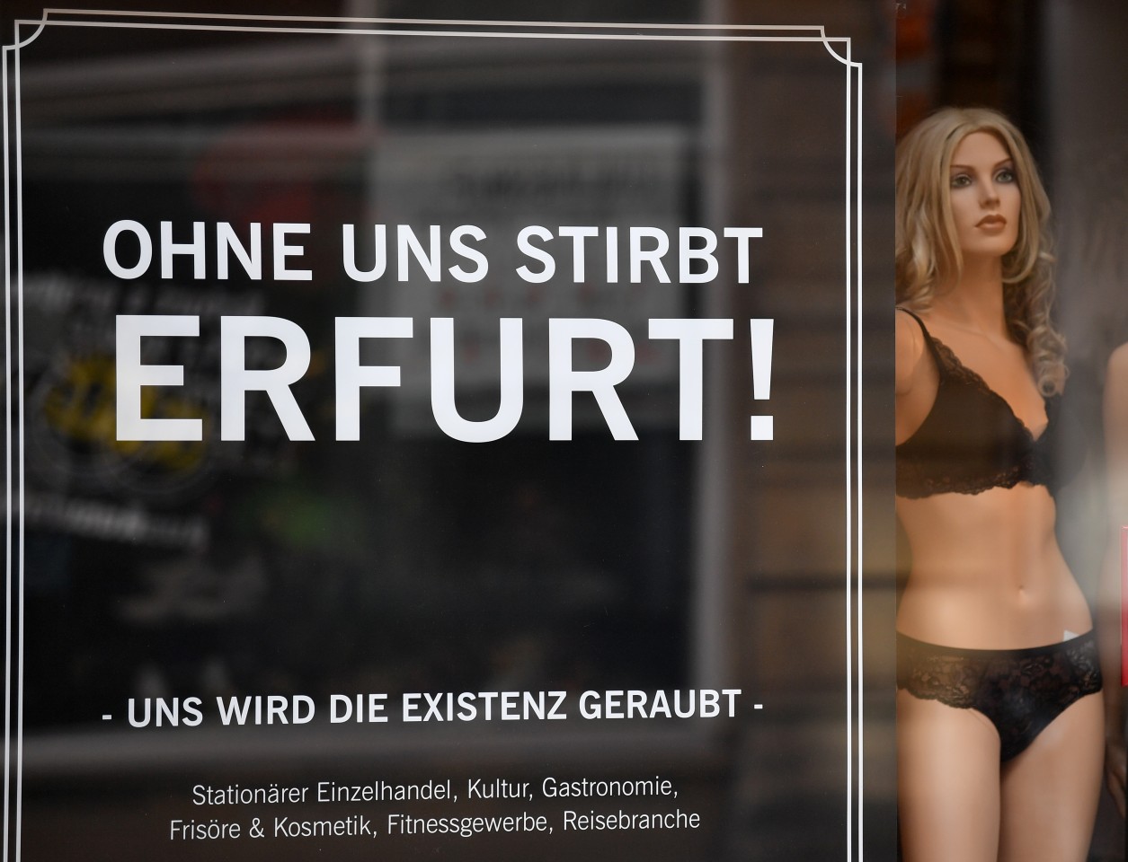 Ein Plakat auf einem Schaufenster eines Bekleidungsgeschäfts in Erfurt.