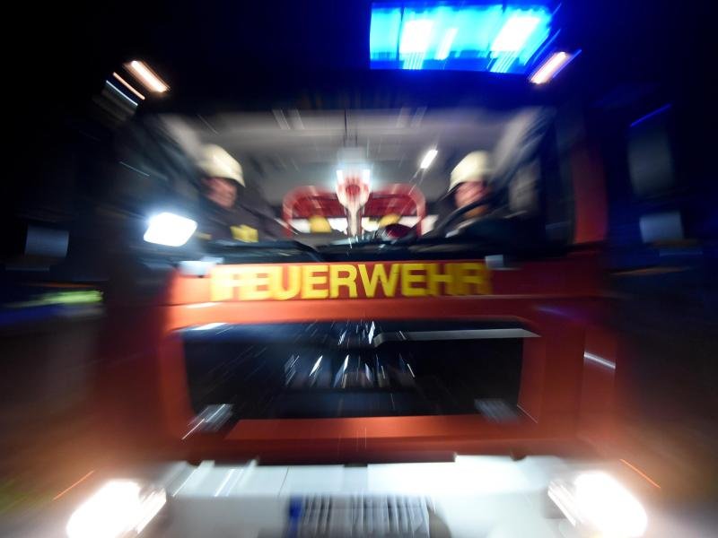 Feuerwehrmänner sitzen bei einer Übung in einem Löschfahrzeug.