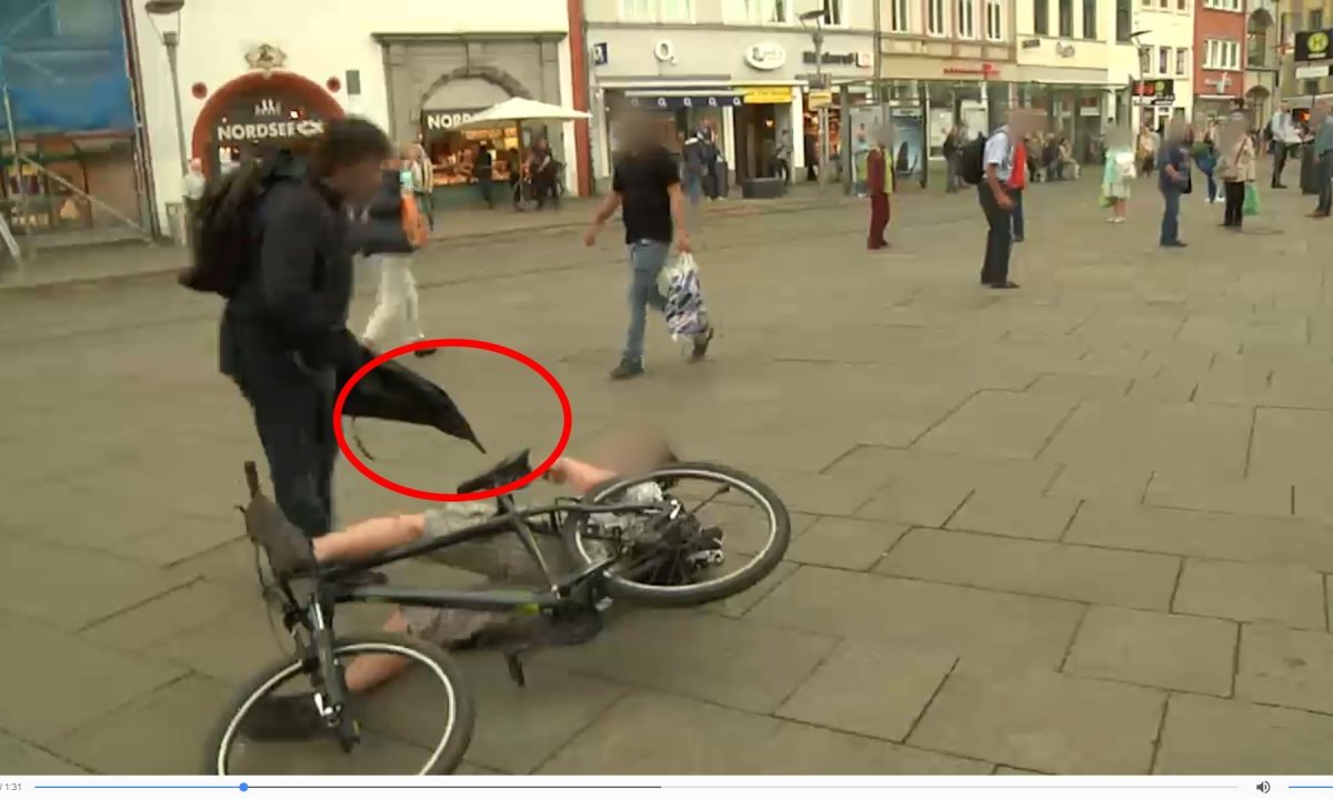 Mann greift mit Regenschirm Fahrradfahrer am Erfurter Anger an