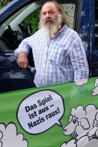 Lothar König, Pfarrer aus Jena, steht bei einer Kundgebung hinter einem Transparent mit der Aufschrift Das Spiel ist aus - Nazis raus. 
