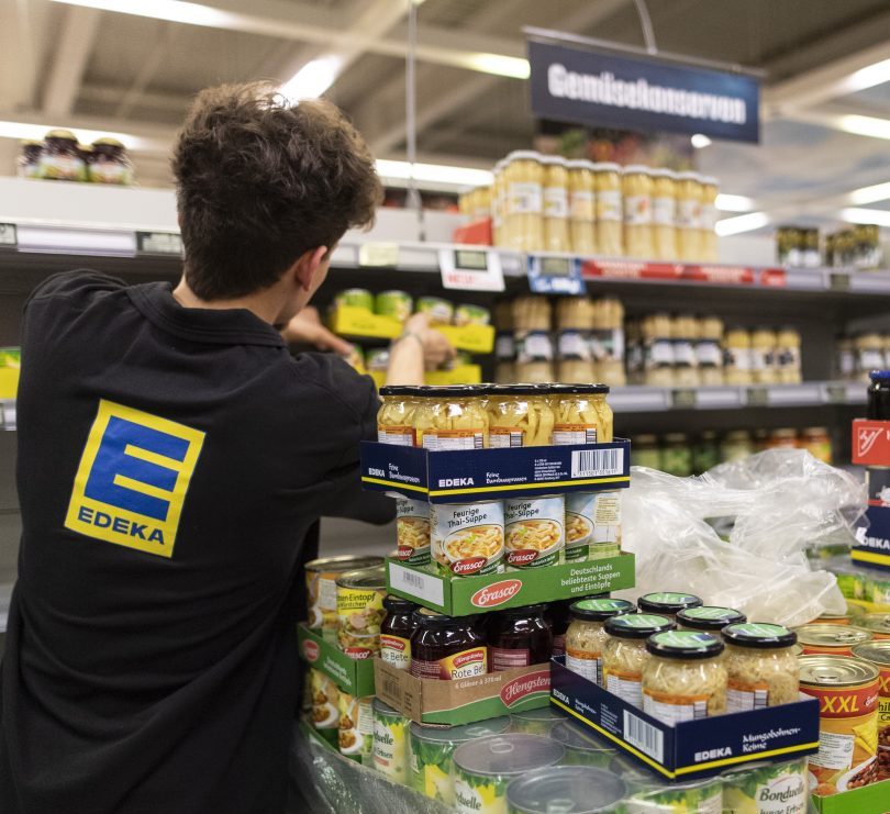 Edeka Mitarbeiter sortiert Lebensmittel